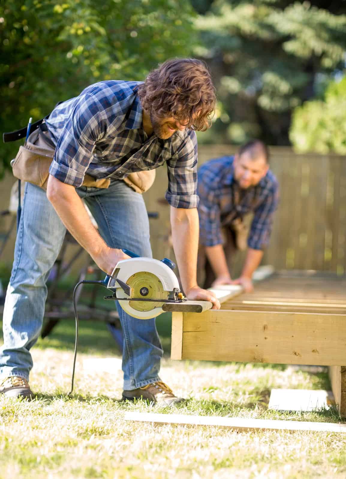 Carpenter-Cutting-Wood-With-Handheld-Saw-While-Coworker-Assistin Pressure Washing Commercial Memphis TN m